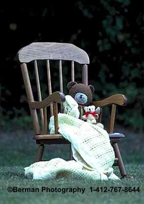 Brown Teddy Bear in a rocking chair holding a Baby Bear