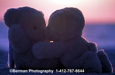 Teddy Bear couple enjoying a romantic moment, kissing while watching the sunset. 