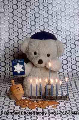 -Teddy Bear celebrating Hanukkah. Wearing his yarmulke, this teddy bear is lighting the traditional Hanukkah menorah.