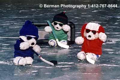 Three Teddy Bears practicing ice hockey. 